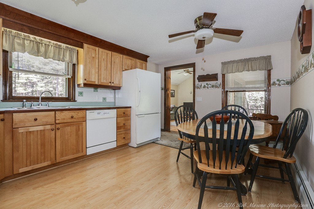 65 Colony Road Phillipston, MA 01331 - Photo 11 of 26 a kitchen with stainless steel appliances kitchen island granite countertop a table chairs in it and wooden floors