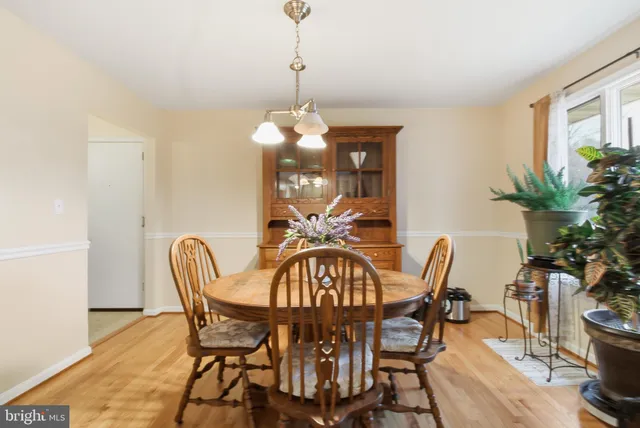 a kitchen with stainless steel appliances granite countertop a sink and a white cabinets with wooden floor