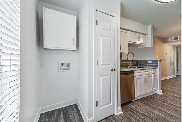 a view of a kitchen with wooden floor a sink a refrigerator and window