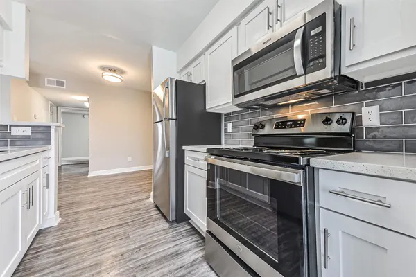 a kitchen with stainless steel appliances granite countertop a stove microwave and a refrigerator