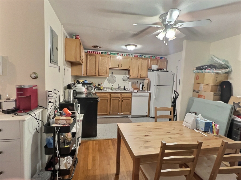 a kitchen that has a table chairs and a refrigerator