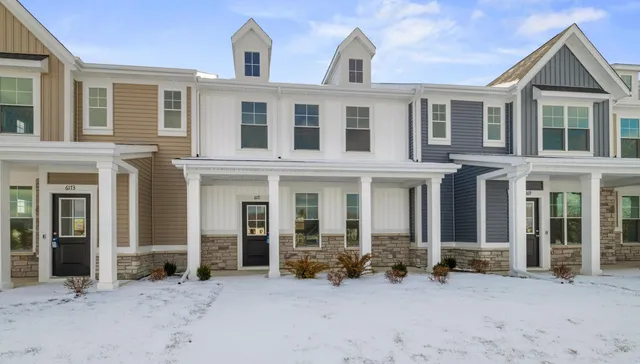 front view of a house with a large windows and a yard