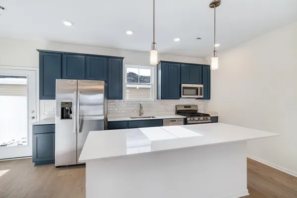 a kitchen with stainless steel appliances a refrigerator sink and microwave