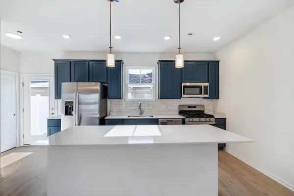 a kitchen with stainless steel appliances a refrigerator sink and microwave