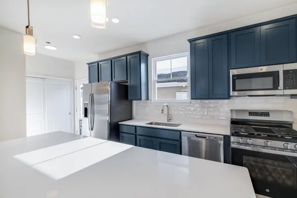 a kitchen with stainless steel appliances a stove refrigerator sink and microwave
