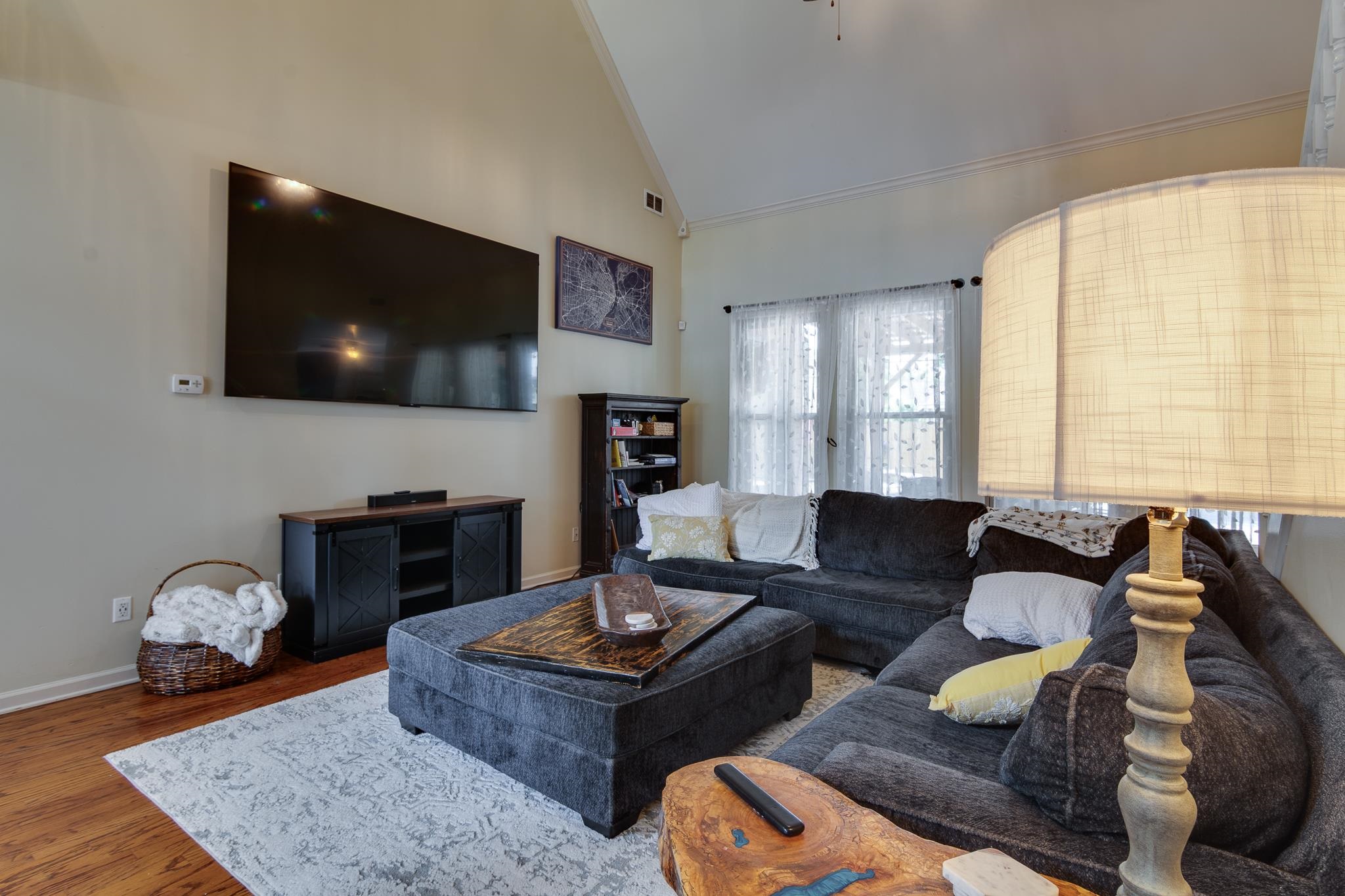 779 Early Earner Cove Collierville, TN 38017 - Photo 7 of 29 Living area featuring vaulted ceilings, wood-finish flooring, and multiple windows with sheer coverings