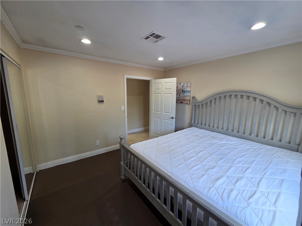 3381 Westwind Road Las Vegas, NV 89146 - Photo 44 of 52 A well-lit bedroom features crown molding, recessed lighting, and ample space for rest.