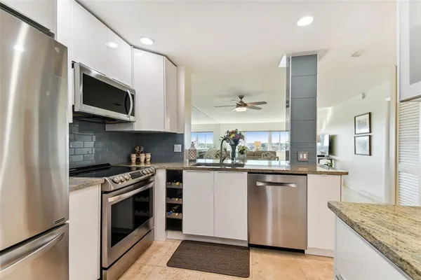 a kitchen with granite countertop a sink a counter top space and cabinets