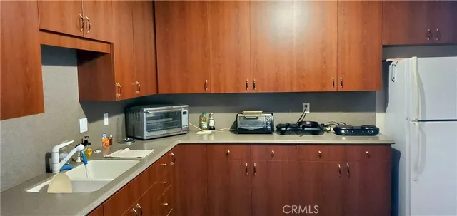 a kitchen with sink a refrigerator and cabinets