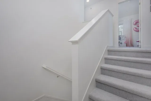 a view of hallway with window and wooden floor