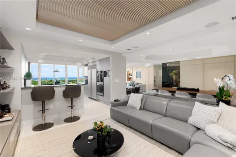 a living room with lots of furniture and view of kitchen