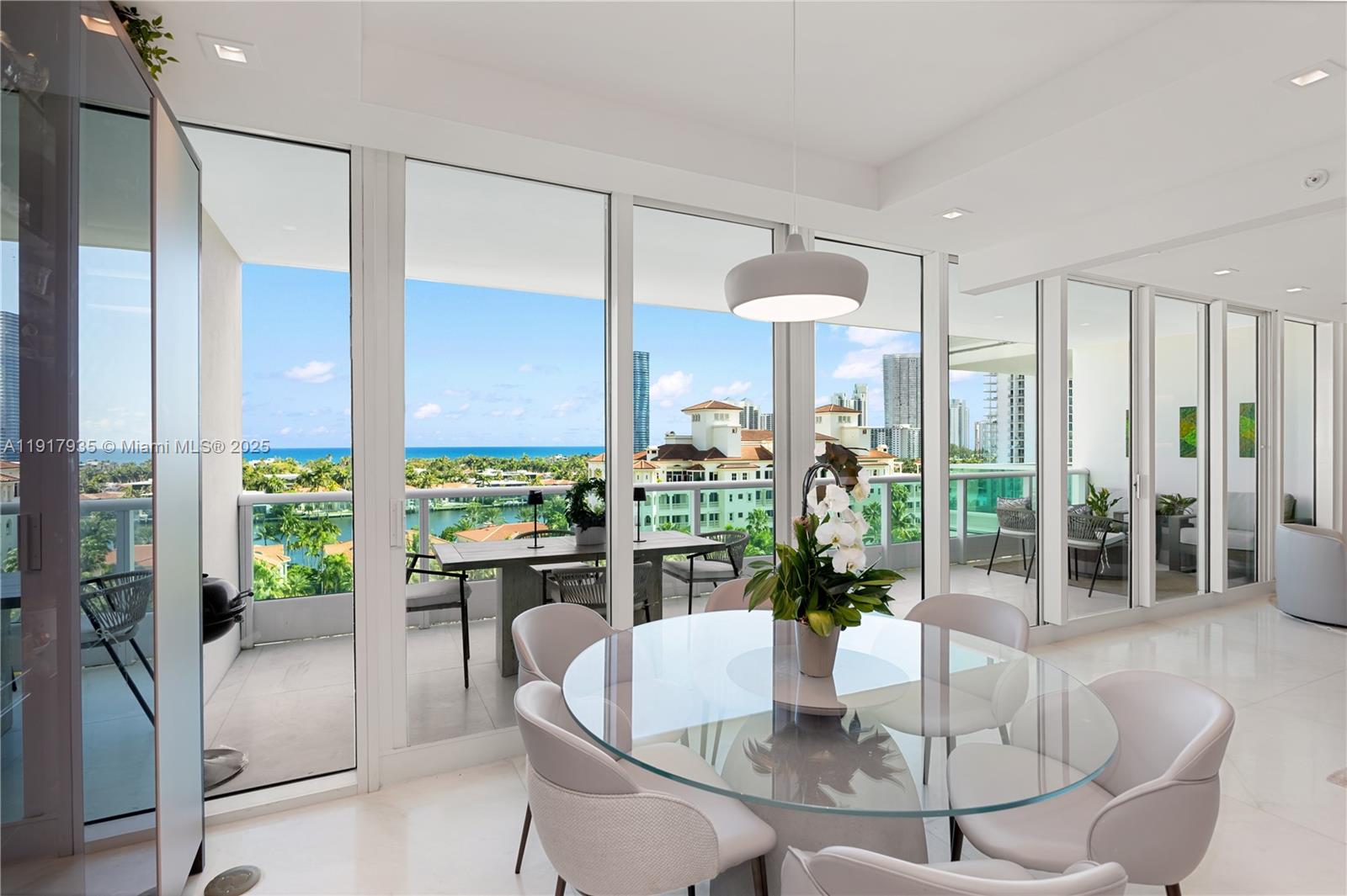 19955 Northeast 38th Court, Unit 1103 Aventura, FL 33180 - Photo 16 of 43 a dining room with furniture a chandelier and wooden floor