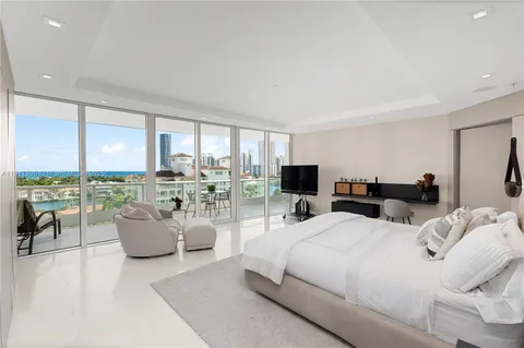 a bedroom with furniture and large windows
