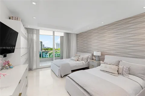 a bedroom with two beds and a flat screen tv