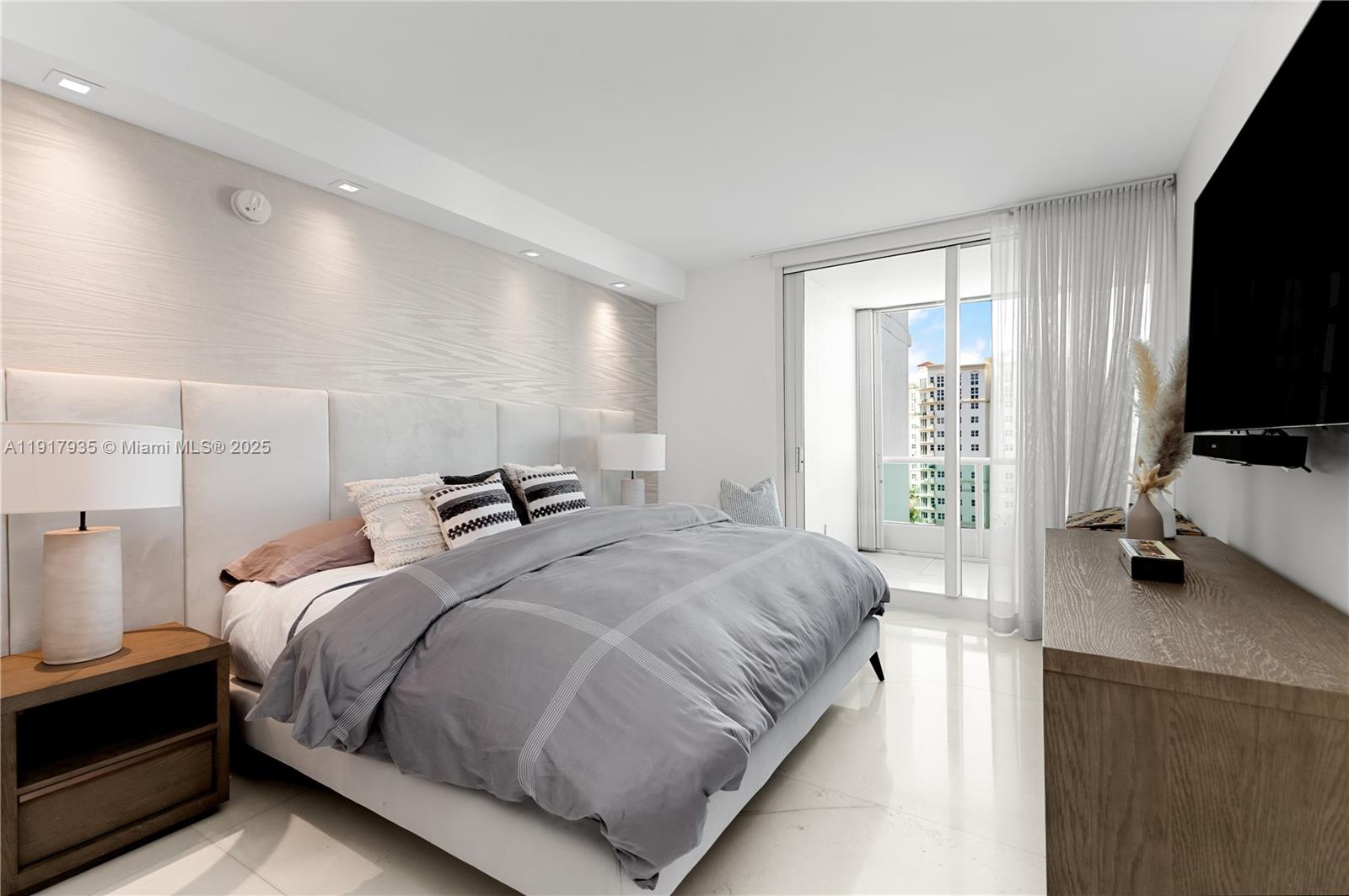 19955 Northeast 38th Court, Unit 1103 Aventura, FL 33180 - Photo 31 of 43 a bedroom with a bed and a flat tv screen on the dresser