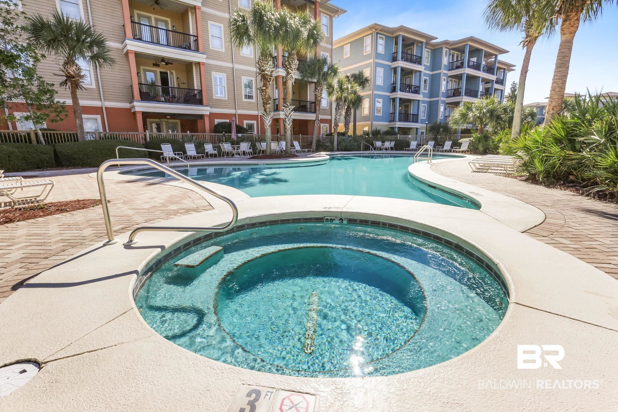 1430 Regency Road, Unit B302 Gulf Shores, AL 36542 - Photo 21 of 24 Community pool with a patio area, a community hot tub, and fence