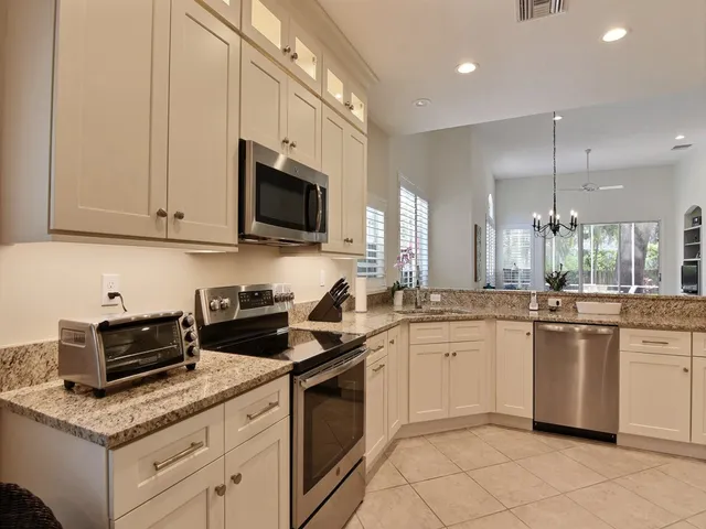 a kitchen with stainless steel appliances granite countertop a sink stove and cabinets