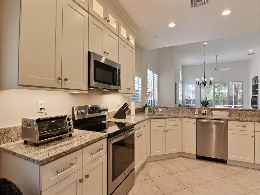 8785 Lakeside Boulevard Vero Beach, FL 32963 - Photo 11 of 36 a kitchen with stainless steel appliances granite countertop a sink stove and cabinets