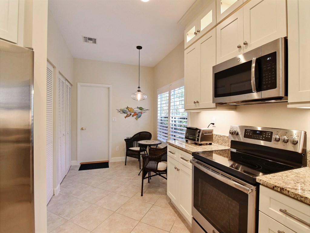 8785 Lakeside Boulevard Vero Beach, FL 32963 - Photo 12 of 36 a kitchen with stainless steel appliances a stove microwave and sink