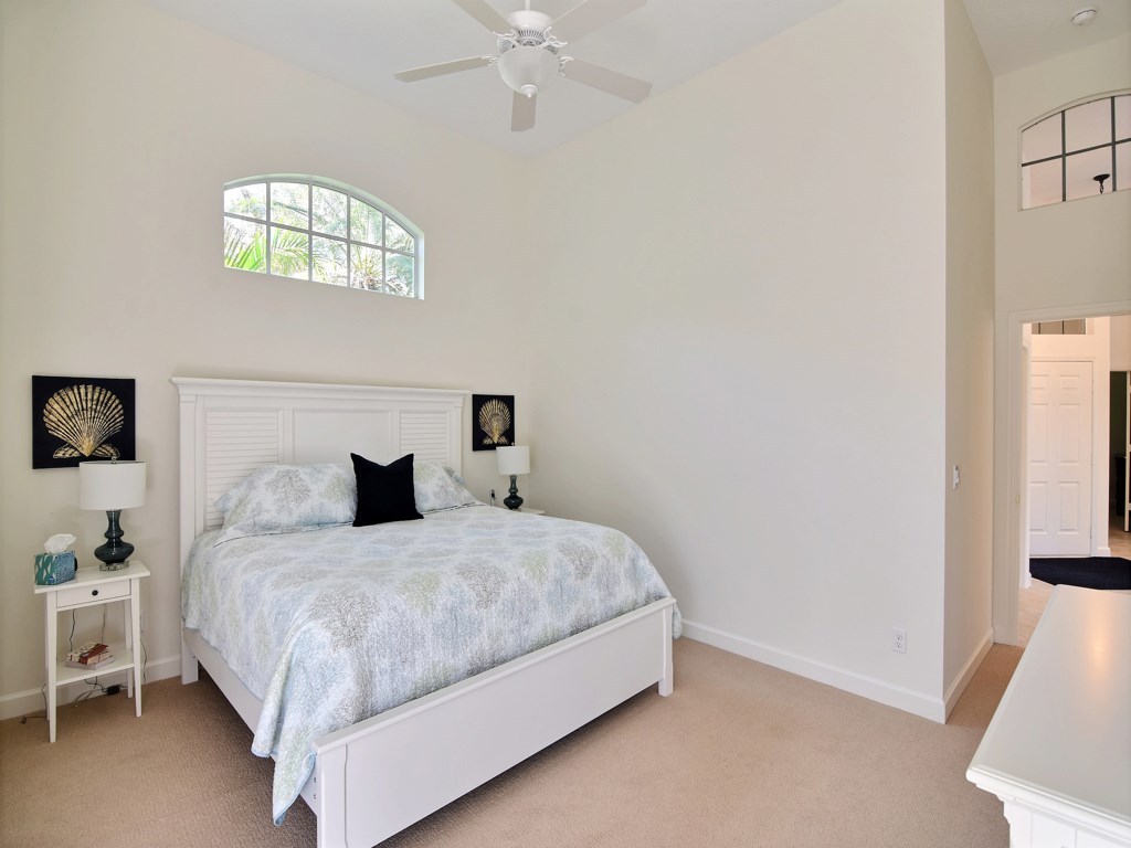 8785 Lakeside Boulevard Vero Beach, FL 32963 - Photo 14 of 36 a bedroom with a bed and a chandelier