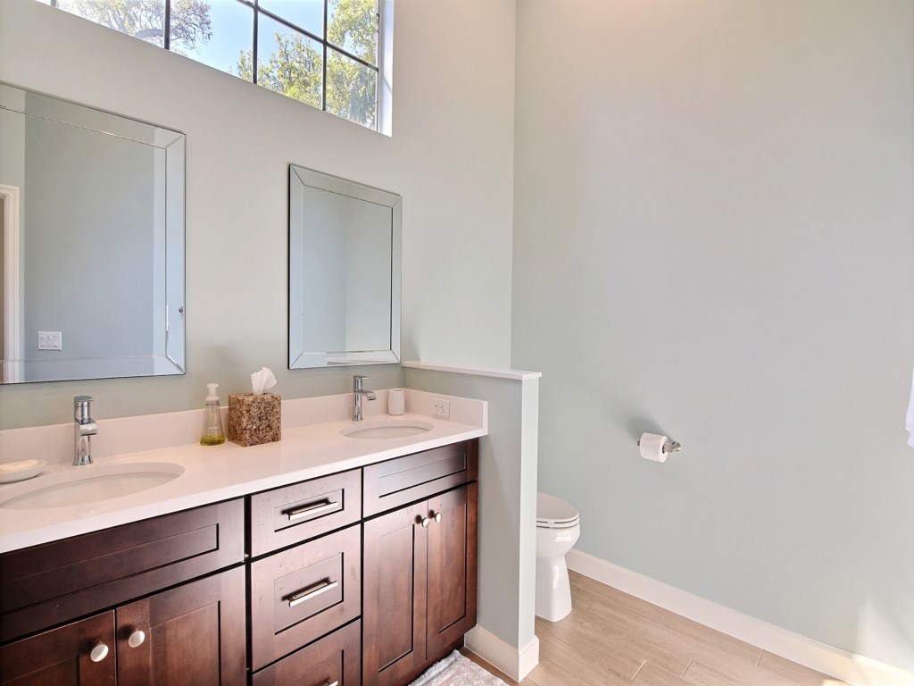 8785 Lakeside Boulevard Vero Beach, FL 32963 - Photo 16 of 36 a bathroom with a sink a toilet and a mirror