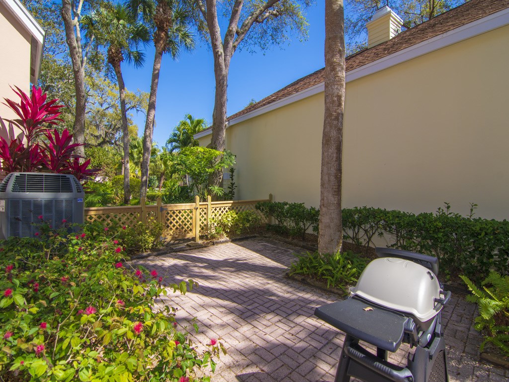 8785 Lakeside Boulevard Vero Beach, FL 32963 - Photo 21 of 36 a view of a backyard with plants and a bench