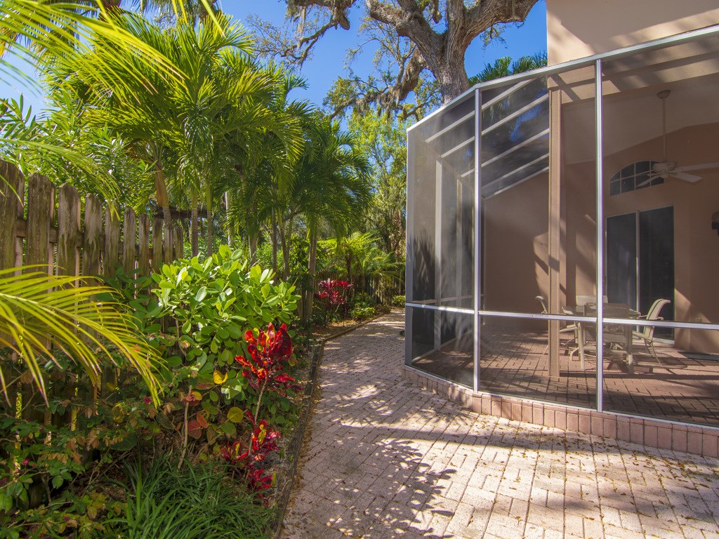 8785 Lakeside Boulevard Vero Beach, FL 32963 - Photo 22 of 36 a backyard of a house with lots of green space and trees in the background