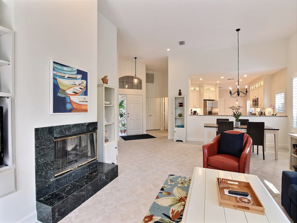 8785 Lakeside Boulevard Vero Beach, FL 32963 - Photo 7 of 36 a living room with furniture a fireplace and kitchen view