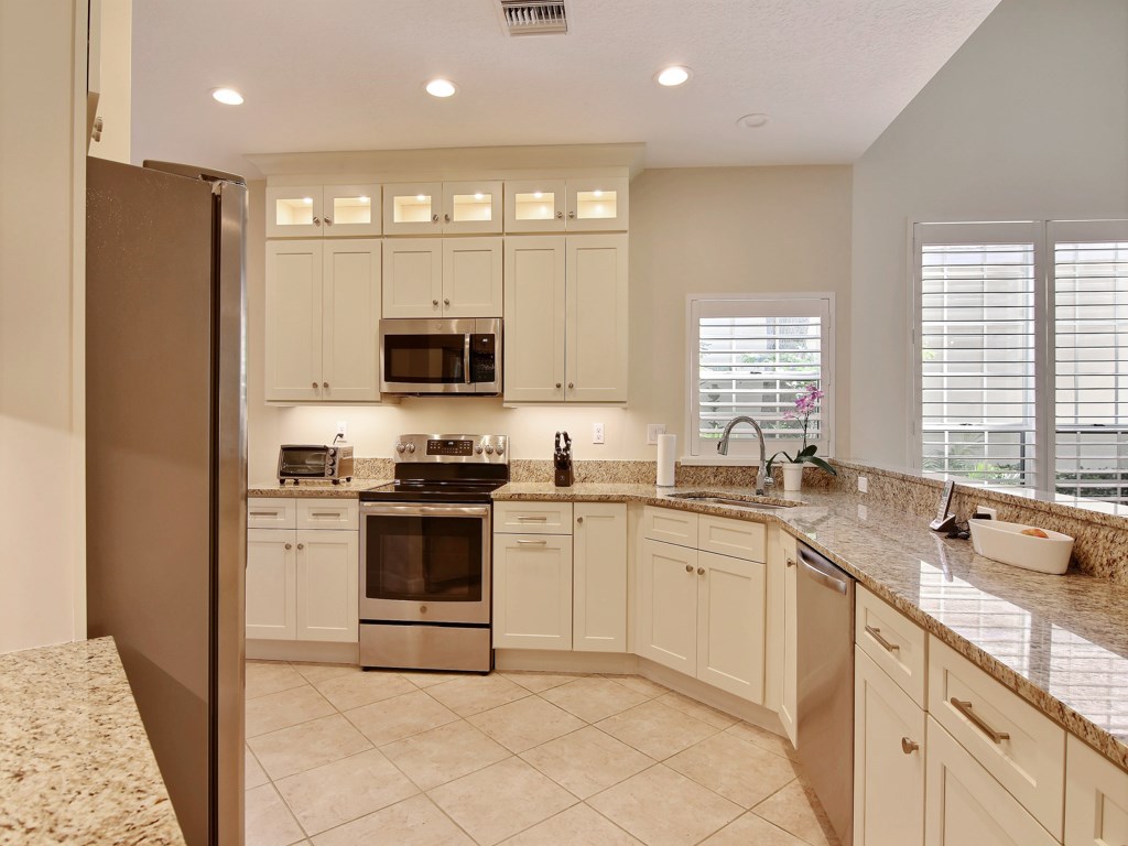 8785 Lakeside Boulevard Vero Beach, FL 32963 - Photo 10 of 36 a kitchen with a sink stove and microwave