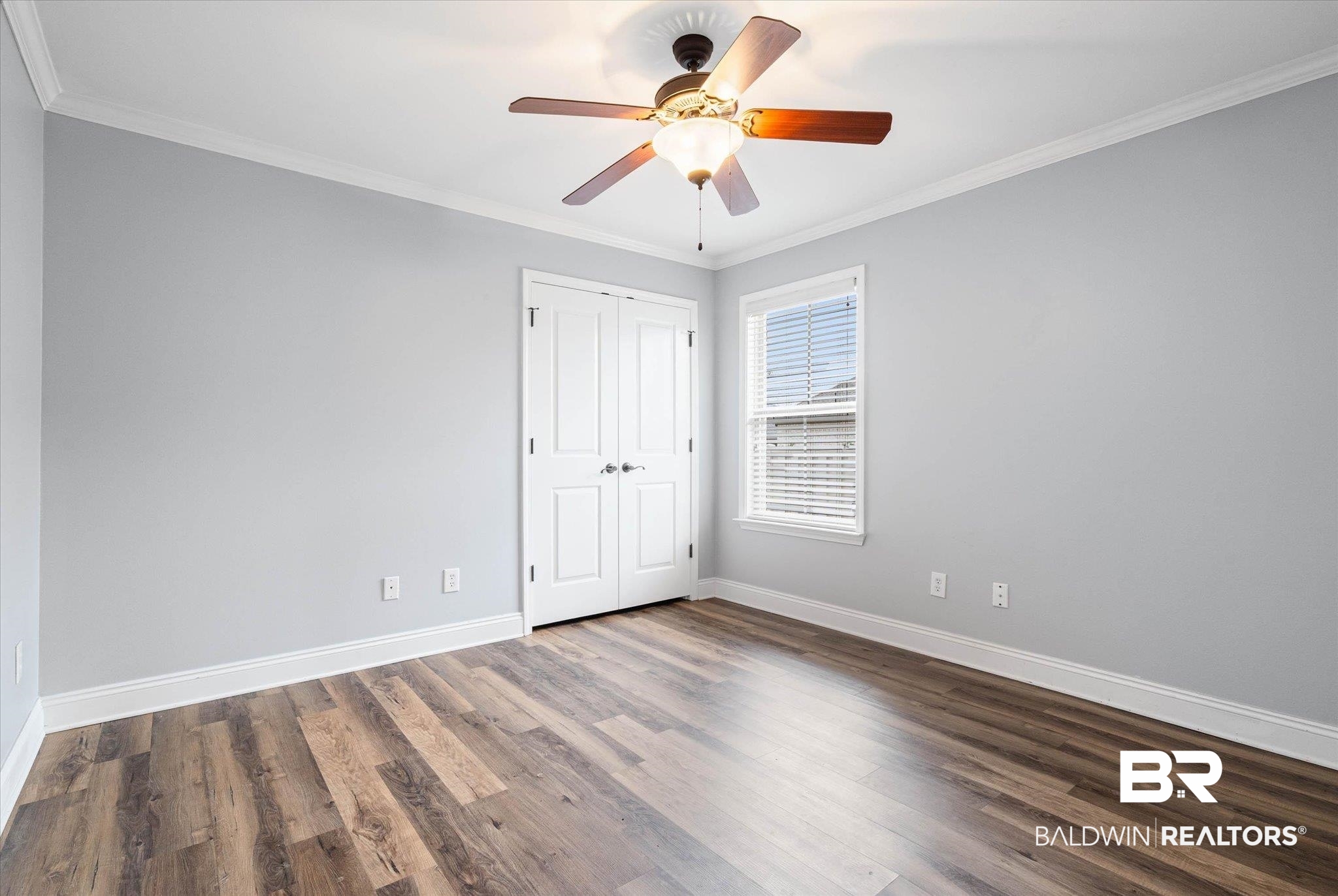 704 Edinburgh Avenue Foley, AL 36535 - Photo 24 of 32 Unfurnished bedroom featuring ornamental molding, dark wood-style floors, a ceiling fan, and a closet