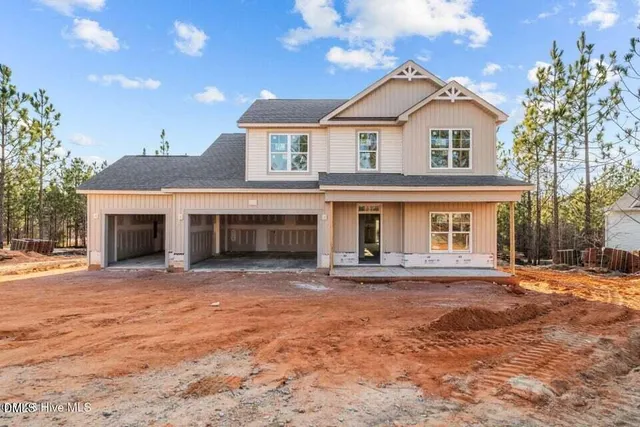 a front view of a house with yard and parking