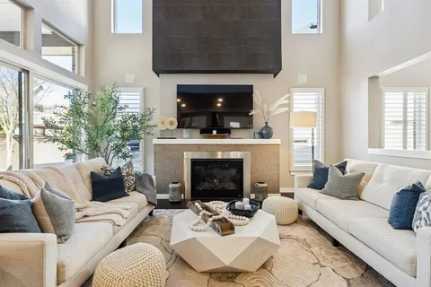 a living room with furniture a fireplace and windows