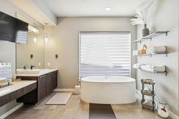 a bathroom with a tub sink and mirror