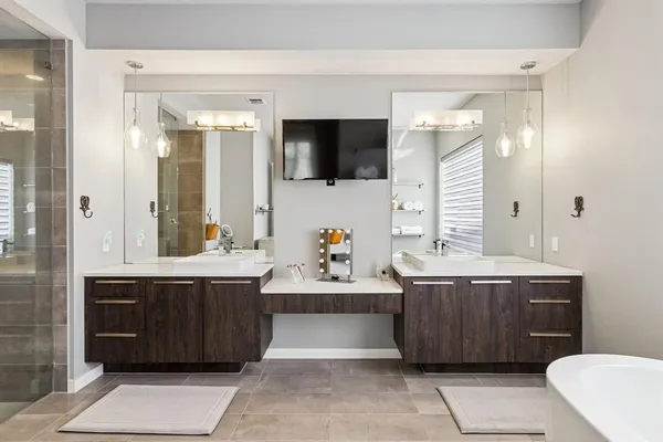 a spacious bathroom with a tub sink and mirror