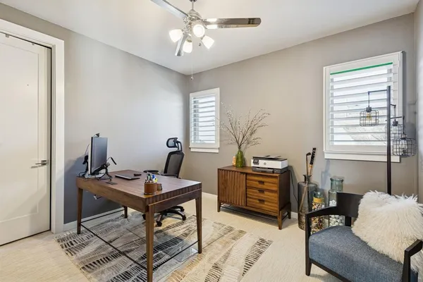 a view of a workspace with furniture and a window