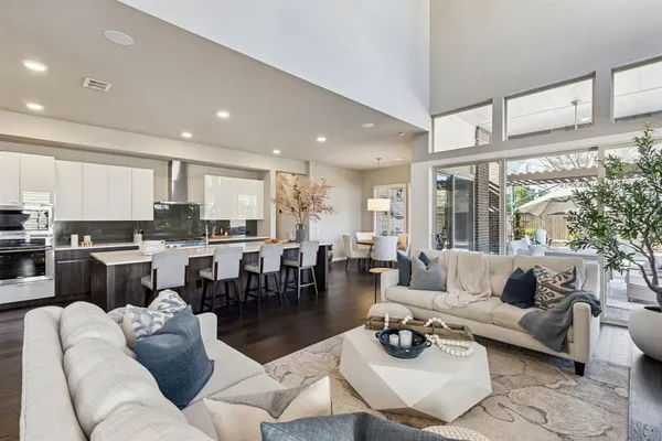 a living room with furniture kitchen and a large window