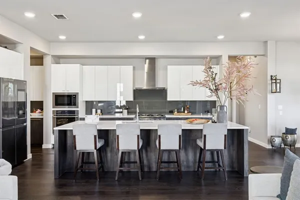 a kitchen with a dining table chairs and refrigerator
