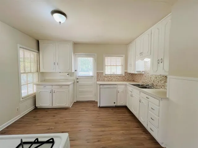 a kitchen with sink a stove and cabinets