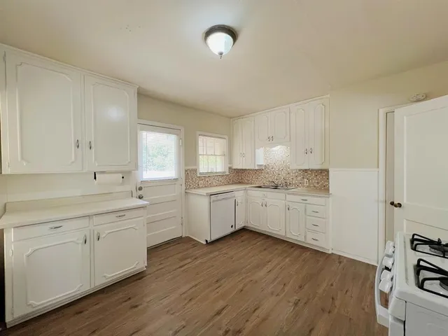a kitchen with cabinets wooden floor and a sink