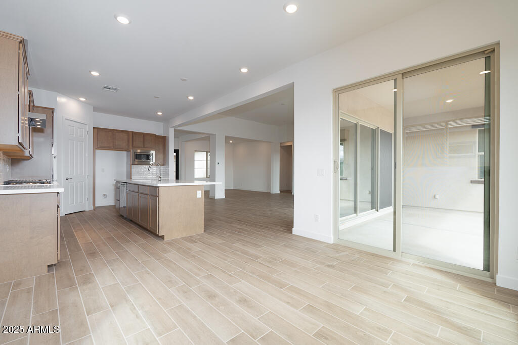 829 Golden Ore Pass Apache Junction, AZ 85120 - Photo 11 of 33 a view of a kitchen with kitchen island wooden floors appliances and a counter top space