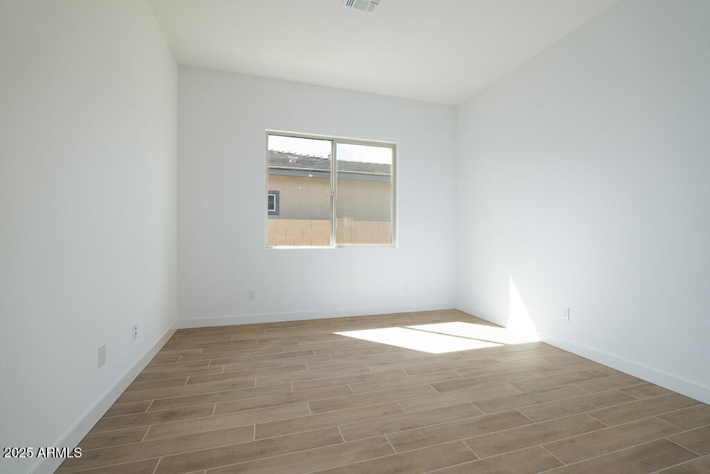 829 Golden Ore Pass Apache Junction, AZ 85120 - Photo 17 of 33 an empty room with wooden floor and windows