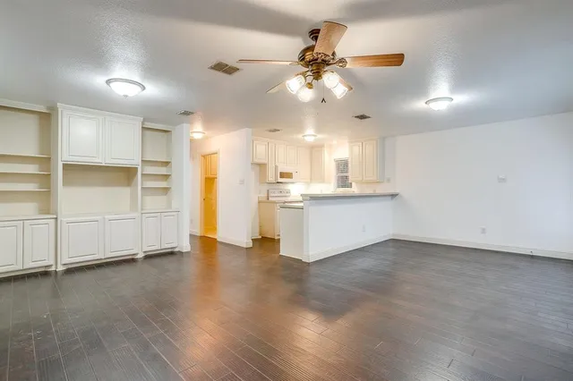 a view of a kitchen with wooden floor and a window