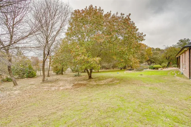 a view of yard with swimming pool and trees