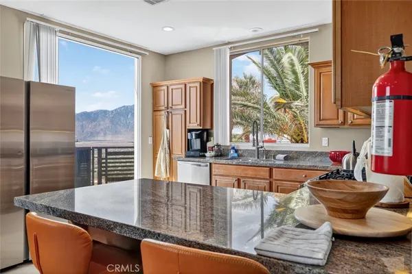 a kitchen with stainless steel appliances granite countertop a sink a stove and a refrigerator
