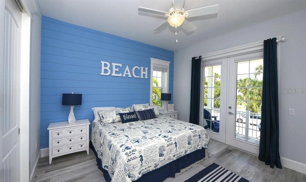 212 Spring Avenue Anna Maria, FL 34216 - Photo 11 of 31 a bedroom with a large bed and a chandelier