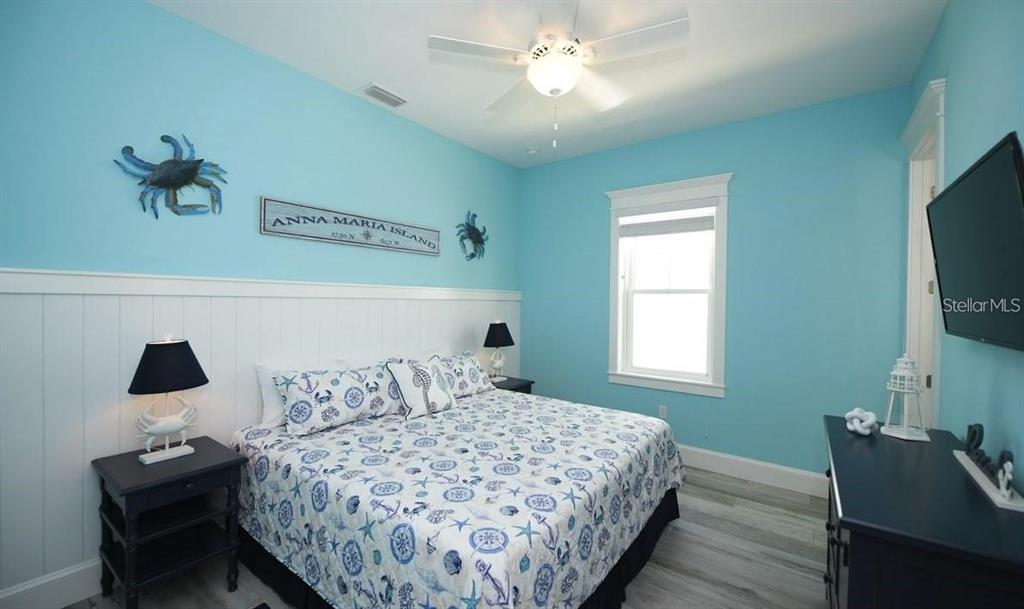 212 Spring Avenue Anna Maria, FL 34216 - Photo 14 of 31 a bedroom with a bed and a flat screen tv