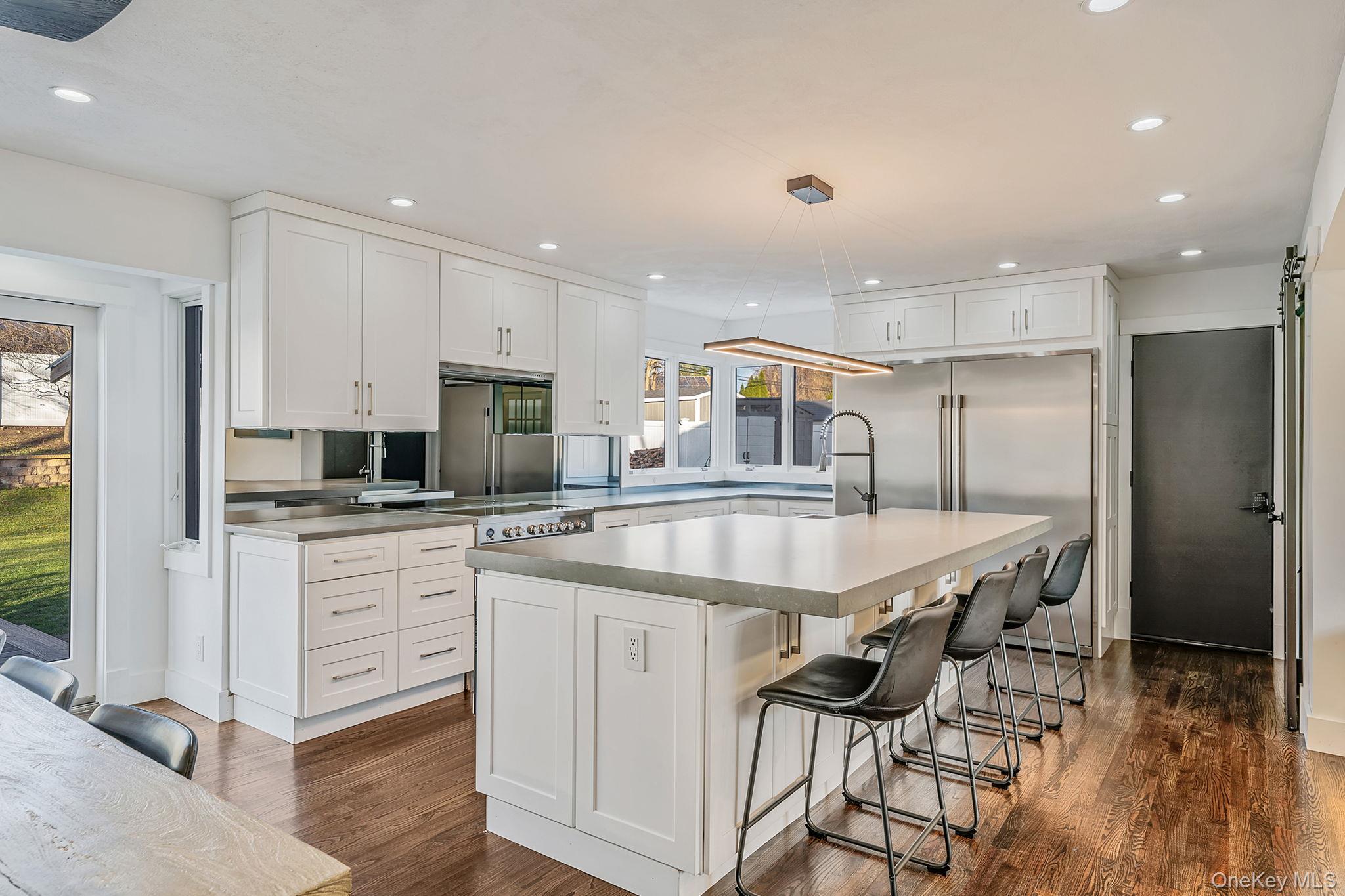 11 Chivalry Lane Nesconset, NY 11767 - Photo 4 of 35 a kitchen with stainless steel appliances kitchen island granite countertop a table chairs sink and cabinets