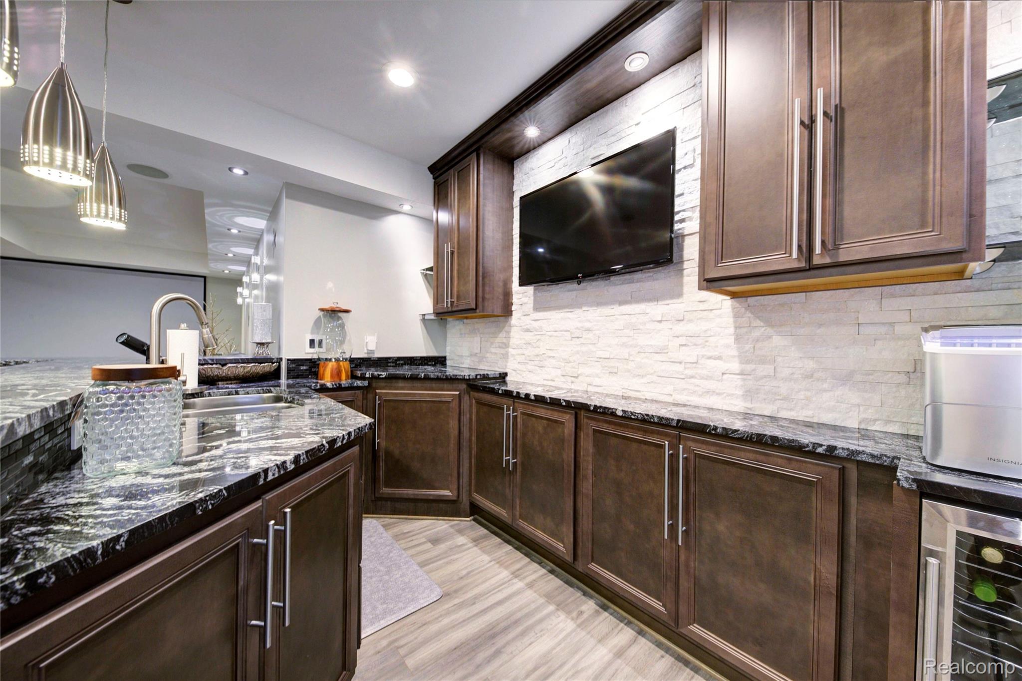 50411 Lansdowne Road Canton, MI 48188 - Photo 44 of 75 Kitchen featuring dark stone countertops, dark wood finish cabinets, pendant lighting, backsplash, and wine cooler