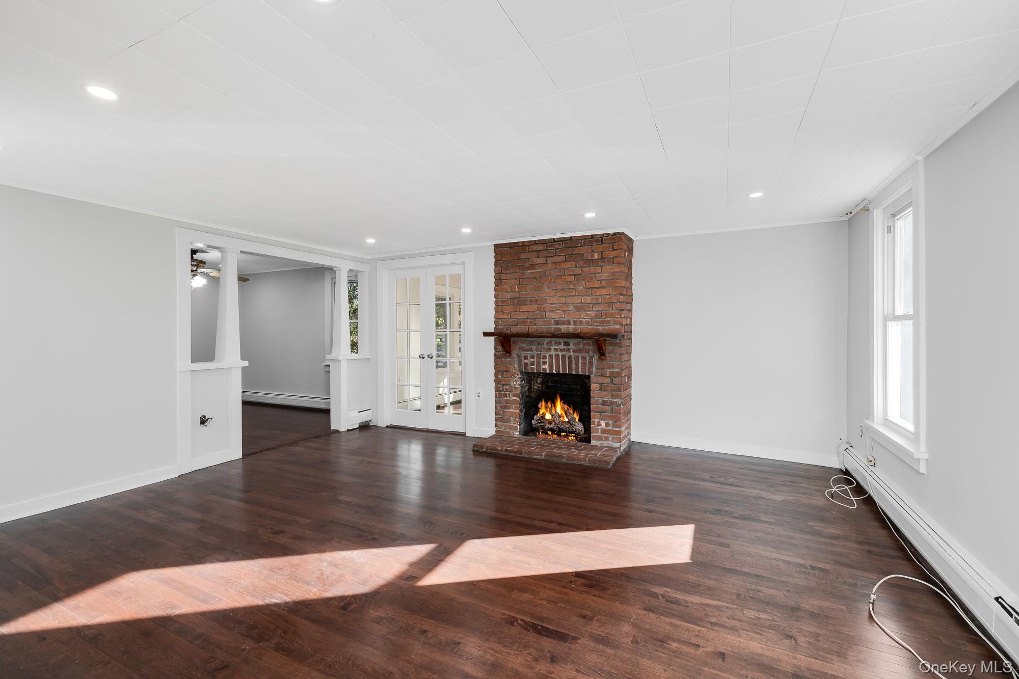122 Rosman Road Thiells, NY 10984 - Photo 19 of 30 a view of an empty room with wooden floor fireplace and a window