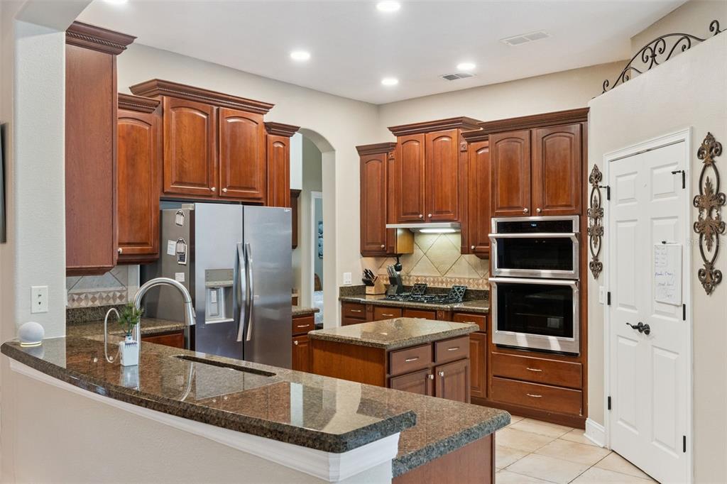 216 Juniper Ridge Court Sanford, FL 32771 - Photo 12 of 61 a kitchen with stainless steel appliances granite countertop a refrigerator and a sink